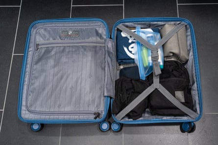 An open suitcase on tile floor