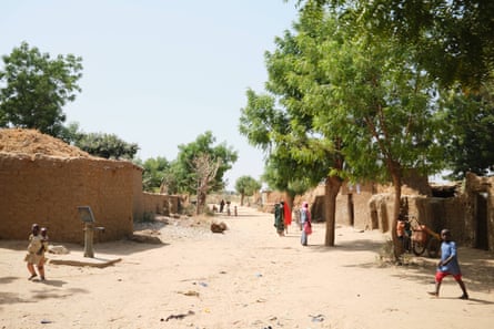 A dirt road with mud buildings on either side