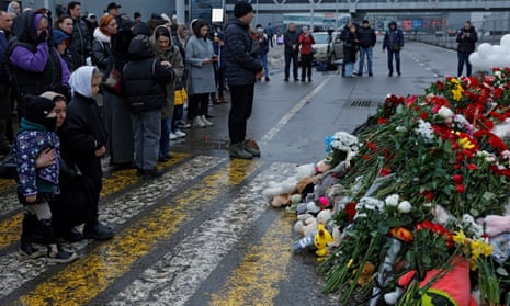 People pay their respects at the memorial set up outside the Crocus City Hall concert venue in the Moscow region of Russia.