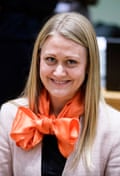 A woman smiles while wearing an orange bow around her neck