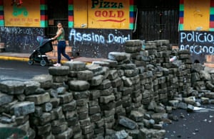 A woman passes a barricade in Masaya, Nicaragua