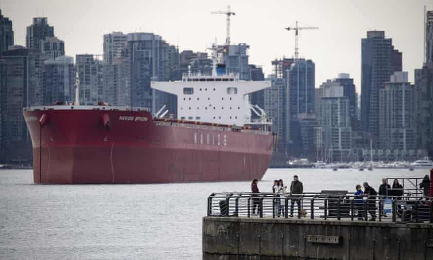 A pier in North Vancouver, with the Navios Sphera bulk carrier ship sitting at anchor.