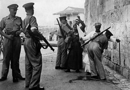 British soldiers searching Arabs for weapons as they enter Jerusalem in 1938.