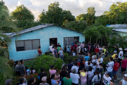 Neighbours gather outside the Guedez García family home during the arrival of the 18 volunteers