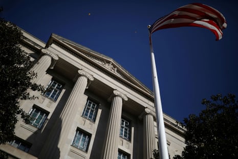 Image of an American flag waving in front of the US Department of Justice building.