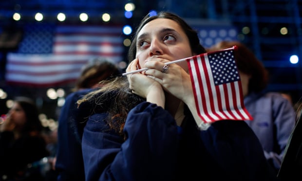 A woman holds an American flag as she watches the US presidential election results