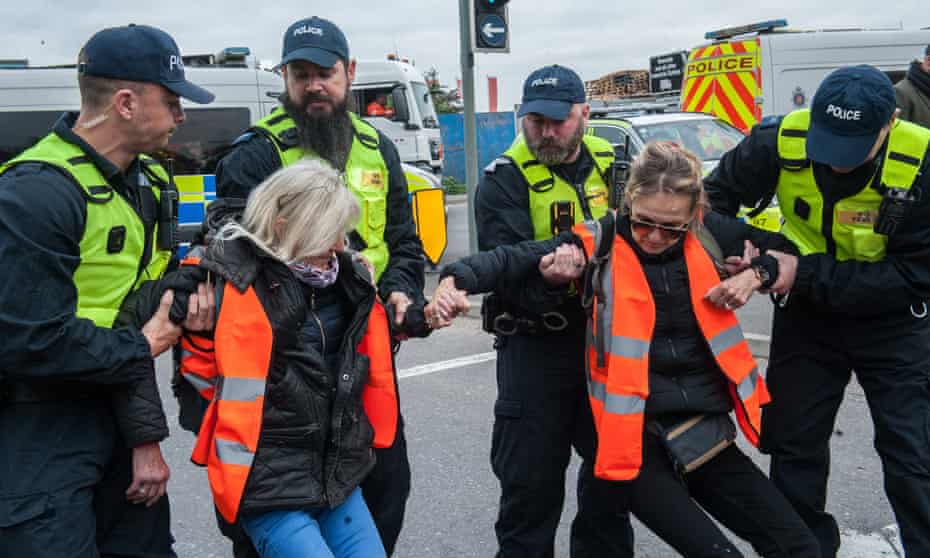 Police removing protesters as activists from Insulate Britain block a junction near the Dartford Crossing in Thurrock, Essex