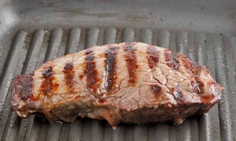 A piece of steak being grilled in a pan