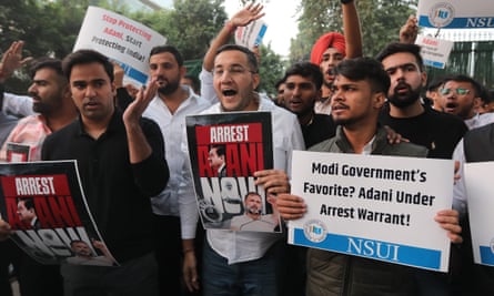 Students hold signs that say 'arrest Adani now'