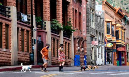 Emily Cayer and Brad Hardy walk their dogs across a quiet Main Street in Bisbee, Arizona.