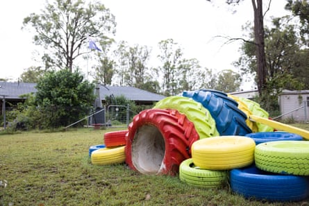 Un tunnel di gioco per cani costruito con pneumatici di trattore dai colori vivaci, in un cortile di periferia.