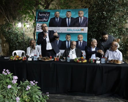 Sami Abu Shehadeh, Ahmad Tibi, Joint List chair Yousef Jabareen and others at a table at a public election meeting.