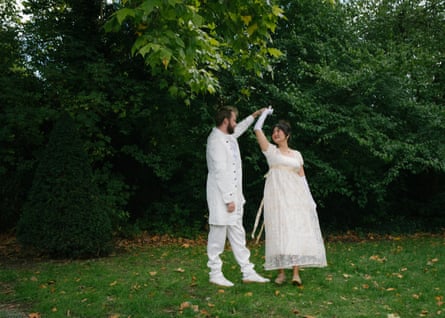 A couple in white dancing in the park
