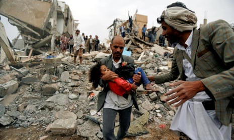 A man carries a child from the site of a Saudi-led air strike that killed eight of her family members in Sana’a, Yemen.