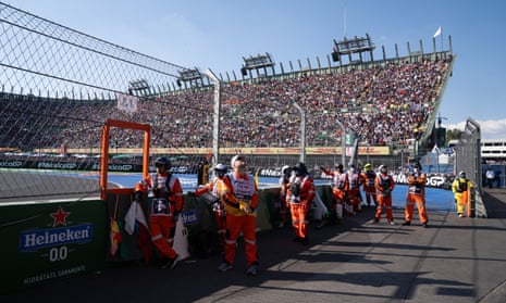 Members of the track team watch the screens after the race is stopped to allow marshals to clear Kevin Magnussen’s car after a crash during lap 33 of the Mexico City Grand Prix.