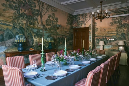 Elegant dining room with 12-seat table surrounded by red and white striped chairs