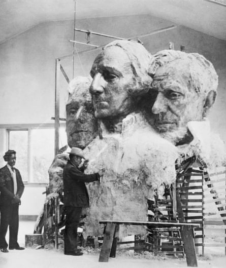 A man works on a model sculpture.