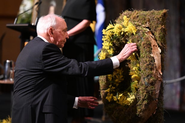 Former prime minister Paul Keating puts a sprig of wattle on a wreath during the memorial service.