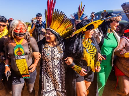 A primeira ministra dos assuntos indígenas do Brasil, Sonia Guajajara, (segunda da esquerda) caminha de braço dado com outras lideranças indígenas em direção à reunião convocada pelo reverenciado cacique Raoni Mekutire