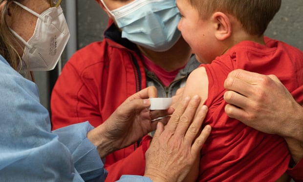 A child receives a shot of Covid-19 vaccine.