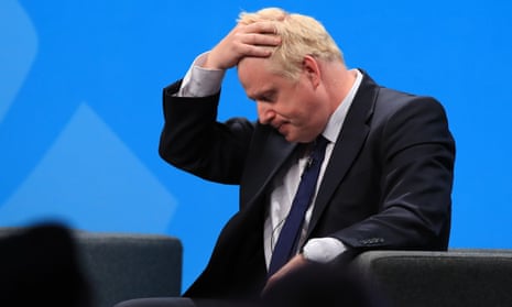 Boris Johnson holds his head in his hands and looks at the floor