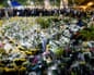 People gather next to a pile of flowers at a makeshift memorial near the Wang Fuk Court housing complex after the deadly fire, in Tai Po, Hong Kong, China, December 1, 2025. REUTERS/Maxim Shemetov