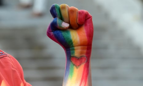A fist painted with the rainbow flag