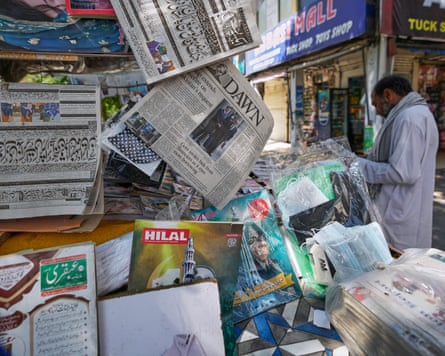 A man reads a morning newspaper outside a stall in Islamabad, Pakistan