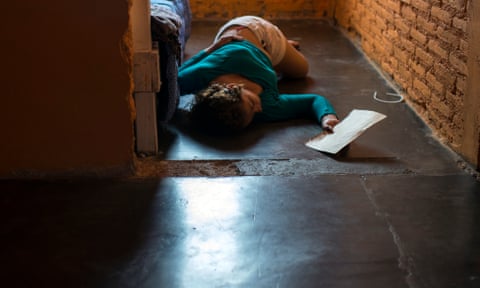 A young woman from Guatemala lies in the floor at a shelter for migrants in Tapachula. She was running from the persecution of a gang member who wanted to force her to be his girlfriend and who killed her boyfriend for confronting him.