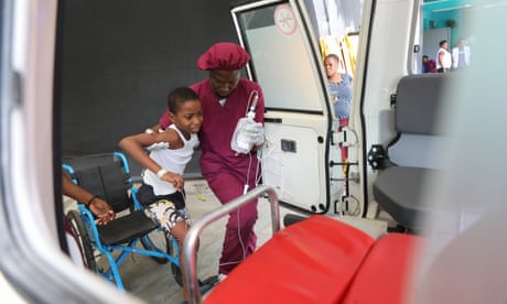 A worker helps a patient at the Doctors Without Borders Hospital in Port-au-Prince, Haiti