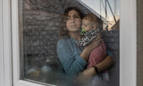 Alina Trebushnikova, 31, at her window with her daughter Polina, three months