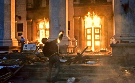 A protester throws a petrol bomb at the Trade Union building in Odessa. 