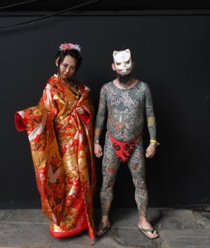 Tattooed visitors pose for photographs during the London Tattoo Convention at Tobacco Dock, in London