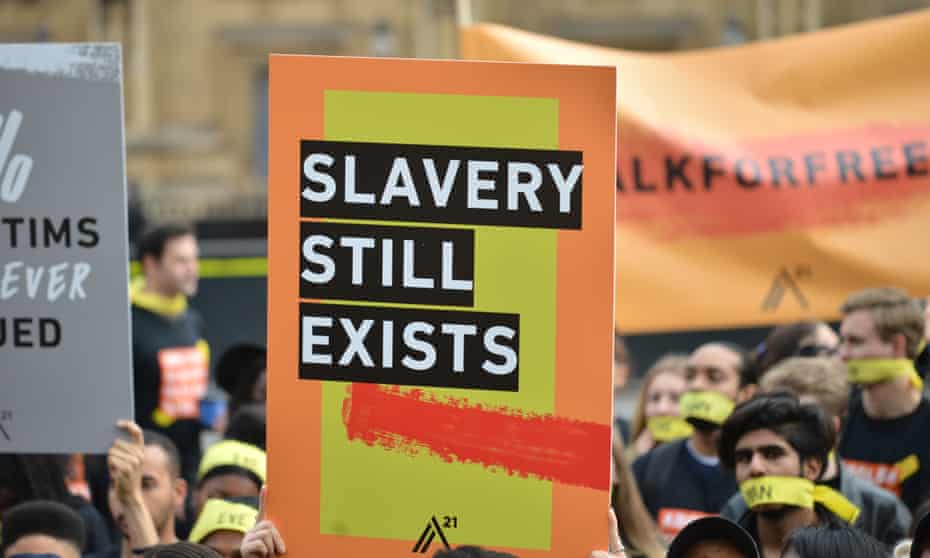 Demonstrators opposed to modern slavery march through London wearing face masks symbolising the silence of people subjected to forced labour and sexual exploitation