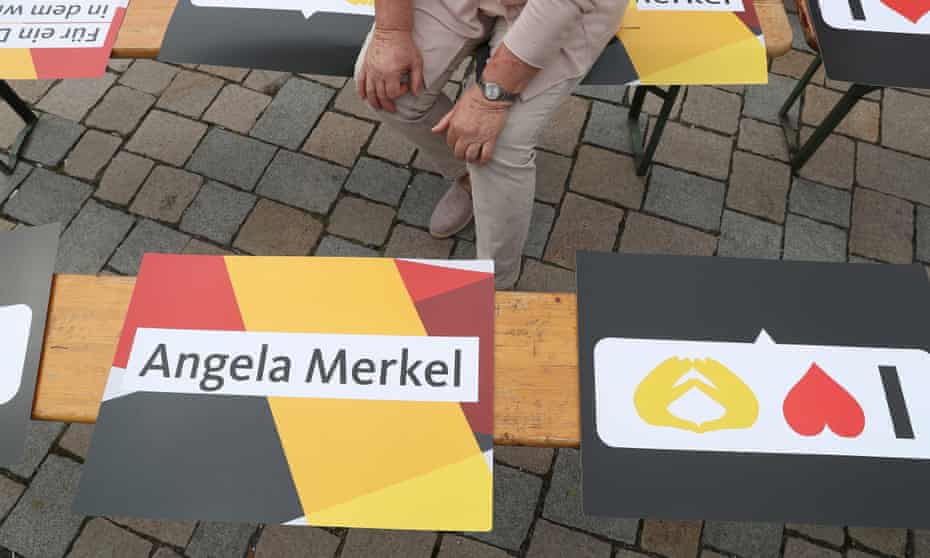 A woman sits among election campaign signs in Germany.
