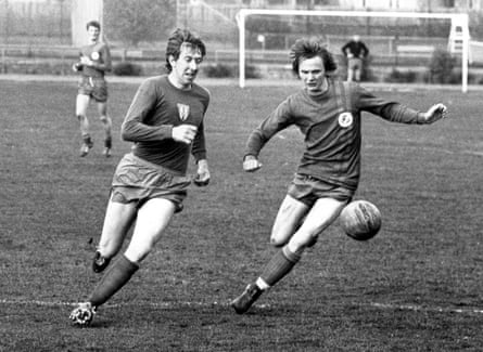 A black and white photograph of Sven-Göran Eriksson and another player chasing the ball on a football pitch