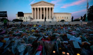 Flowers, candles, and signs are pictured at a memorial outside the supreme court.
