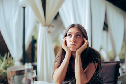 A stressed woman sits alone at a table at a formal event