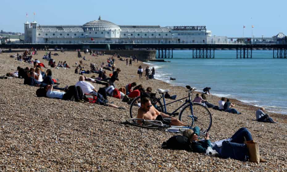 People enjoy the warm weather on the beach in Brighton, East Sussex