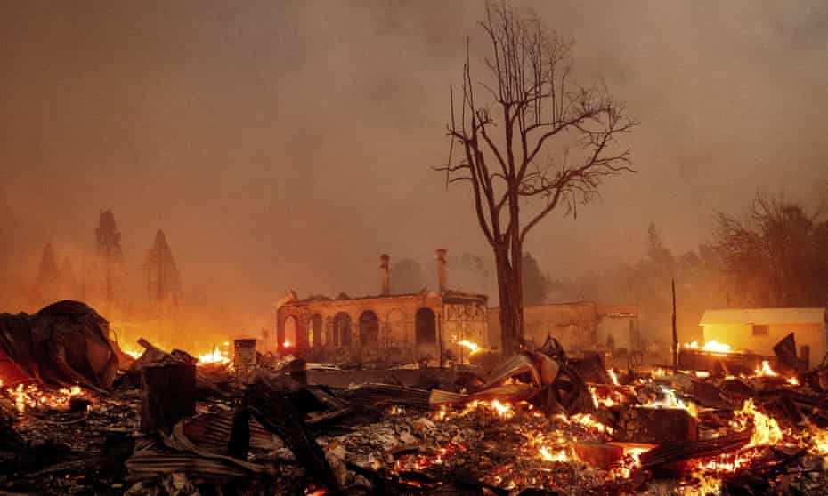 Buildings burn as the Dixie fire tears through the Greenville community of Plumas county, California.