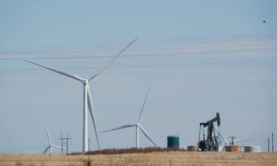 Wind turbines spin as a pump jack pulls up oil in west Texas.