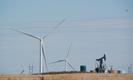 Wind turbines spin as a pump jack pulls up oil in west Texas.