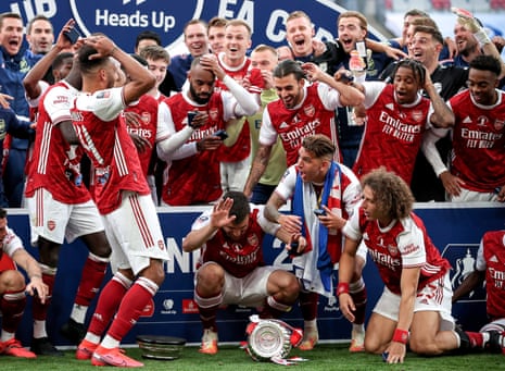 Arsenal’s Pierre-Emerick Aubameyang (centre) drops the FA Cup troph.