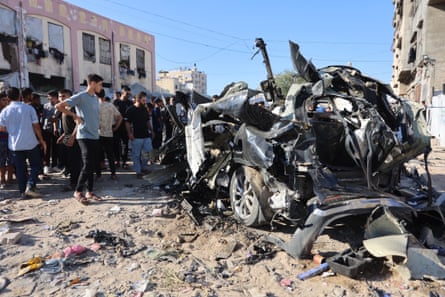People stand beside the vehicle’s twisted wreckage