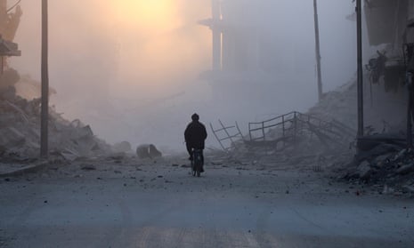 A man cycles near damaged buildings after a strike on the rebel-held al-Shaar area of Aleppo.
