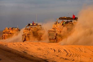 Three Israeli tanks drive in the sand