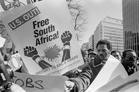 A Black man amid many signs including one that reads “Free South Africa”.