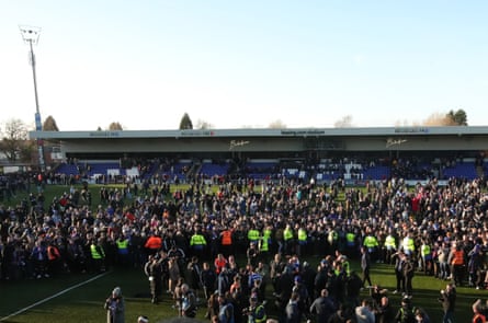 Macclesfield fans celebrate on the pitch at Moss Rose after their seismic FA Cup shock.