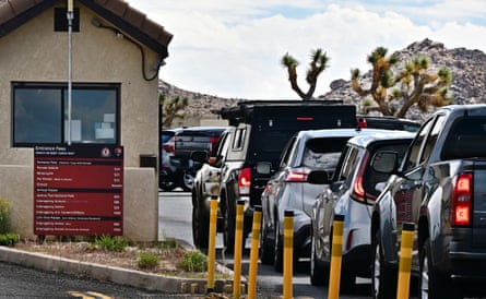 A line of cars with red tail lights at a ranger station.