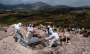 Cemetery workers wearing protective gear bury an unclaimed Covid-19 coronavirus victim, at the Municipal cemetery No. 13 in Tijuana, Baja California state, Mexico, on April 21, 2020.